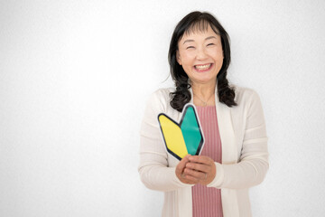 初心者マークを持った中高年女性