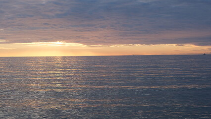 海岸から見る、太陽が海に沈む景色。
