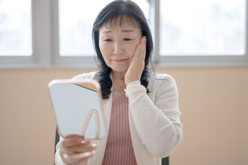 肌を触って悲しそうな中高年女性