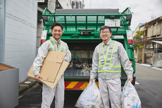 パッカー車とゴミを持つ男性の作業員