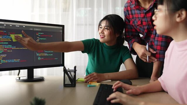 Slow motion back end software developer engineer for computer programming working together on debugging writing computing code, solving complex algorithms display on monitor in office. Burgeoning