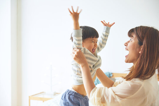 万歳をする男の子と笑顔の母