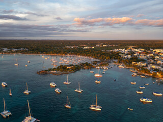 Aerial drone view of a small tourist town Bayahibe, beach and marina with yachts and boats at the...