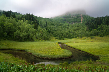View from the tourist trail to the Dukka Lakes to the valley of the Malaya Dukka River, surrounded by the mountains of the North Caucasus on a sunny summer day, Arkhyz, Karachay-Cherkessia, Russia © Ula Ulachka