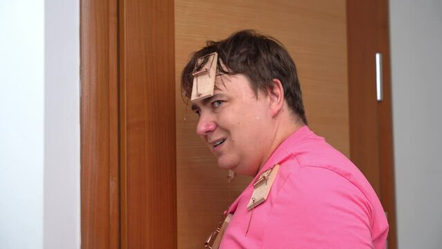 Man closes door, removes mousetrap from nose, looks angrily, comes up with cunning plan for revenge, is obsessed with confrontation, decisively raises finger, idea April Fool Day prank confrontation 