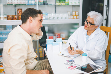 Obraz premium Pharmacist giving advice And advice for patients who come to buy Medicine, Drugs, Vitamins products, according to prescriptions in modern pharmacies.
