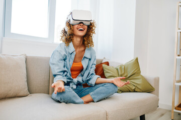 Smiling woman enjoying virtual reality game in futuristic home interior with VR goggles and...