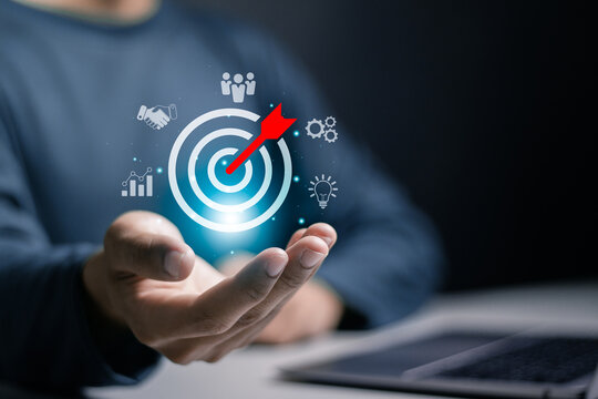 Business target concept.  Businessman holding target icon for business strategy and future sustainable business finance action plan. Business leadership, success and sustainable goals.
