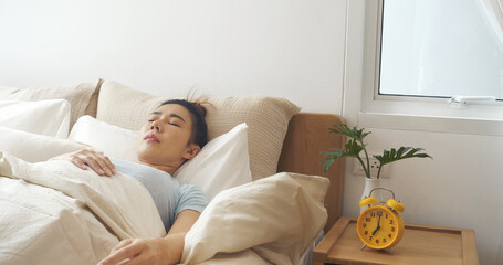 Asian women sleep wake up in white cozy bedroom happy time morning sunrise. Beautiful chinese use...