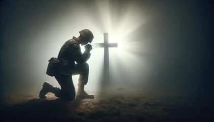 Poster A poignant scene of a soldier in uniform kneeling in solemn prayer beside a rugged cross on a misty battlefield. © Preyanuch
