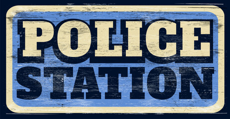 Aged and worn police station sign on wood