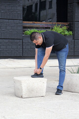 Latin adult man wears black tennis shoes that serve to protect the foot from friction with a...