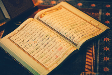 Obraz premium The Quran was opened for reading and had a dim golden glow. Selective focus. The concept of Islam.