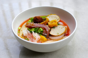 A bowl of pink flat noodles