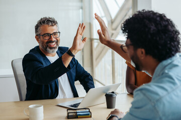 Successful business collaboration between two professional male colleagues in a startup office