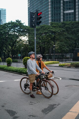 A young couple riding their bikes in the city.