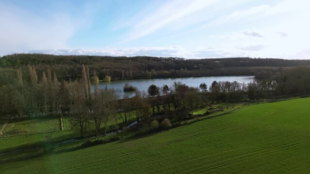 Dampierre sur Avre pond and surrounding countryside, France. Aerial drone ascending and sky for copy space