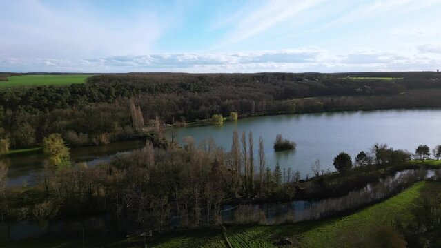 Dampierre sur Avre pond and surrounding rural landscape, France. Aerial sideways and sky for copy space