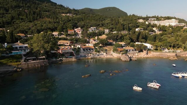 Aerial dolly to coastal view homes with perfect window seating to look out on water and sunset in Corfu Greece