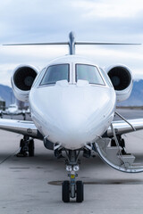 Close up front view of the nose of a small private jet airplane sitting on the tarmac ready to be...