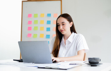 Asian businesswoman sit at their desks and calculate financial graphs showing results about their investments, plan a successful business growth process