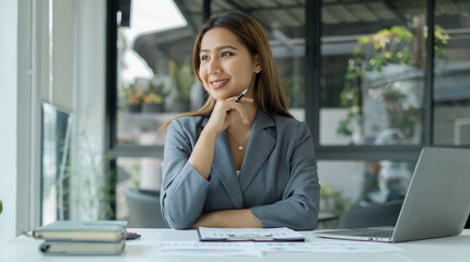 Asian businesswoman calculate financial graphs showing results about their investments, plan a...