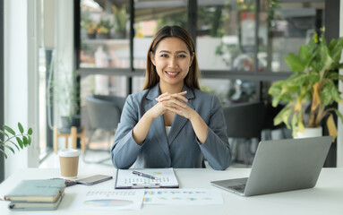 Asian businesswoman calculate financial graphs showing results about their investments, plan a...