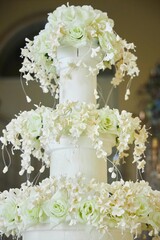 Confectionery for the festive table. A big wedding cake. Decoration of marzipan and fresh flowers