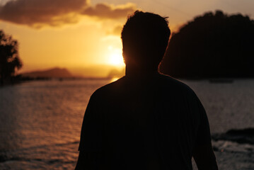 Silhouette of a man watching the sunset over the beach in the Philippines