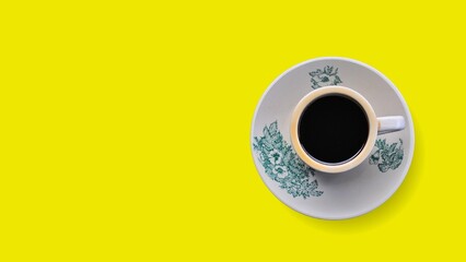 a cup of black coffee on yellow background