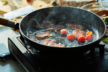 Roast garlic, cherry tomatoes and Chorizo sausage in a hot pan. The cooking process, step-by-step recipe