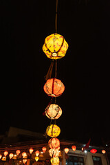 Brightly colourful lanterns hanging along a string