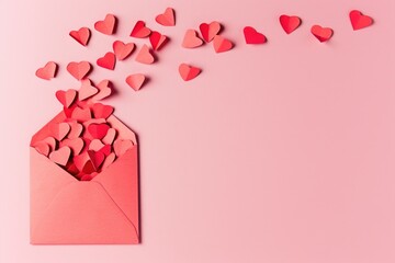 Red envelope with many hearts is open on pink background