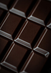 Close up macro of squares of a bar of dark chocolate from above.