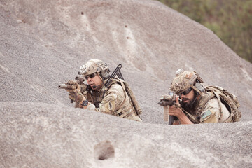 Soldiers in camouflage military uniforms carrying weapons, Reconnaissance missions in rugged mountains, Assault infantry battle training.