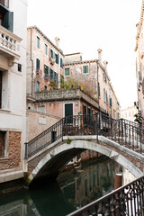 Fototapeta na wymiar Quiet Venetian canal with arched bridge