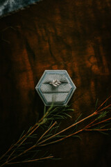 Diamond wedding ring in blue hexagon ring box with wooden background