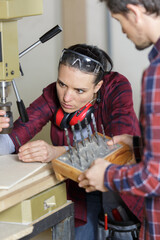 Fototapeta na wymiar carpenter teaching apprentice how to cut wood