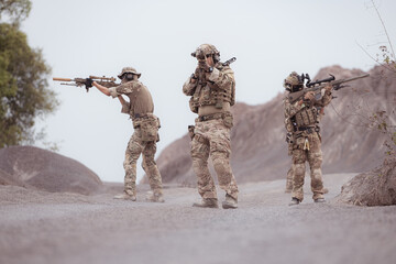 Soldiers in camouflage military uniforms carrying weapons, Reconnaissance missions in rugged mountains, Assault infantry battle training.