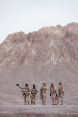 Soldiers in camouflage military uniforms carrying weapons, Reconnaissance missions in rugged mountains, Assault infantry battle training.