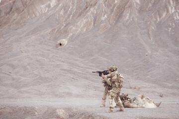 Soldiers in camouflage military uniforms carrying weapons, Reconnaissance missions in rugged...