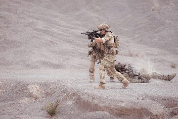 Soldiers in camouflage military uniforms carrying weapons, Reconnaissance missions in rugged...