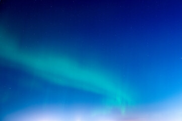 Green Aurora borealis or polar lights on night blue sky