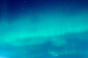 Green Aurora borealis or polar lights on night blue sky