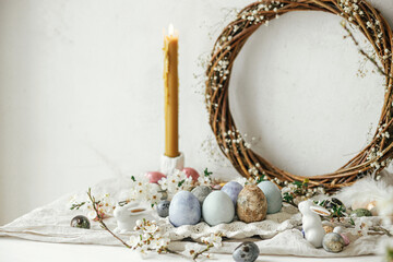 Fototapeta na wymiar Stylish easter eggs, bunnies and cherry blossom composition on rustic table. Happy Easter! Modern natural dyed and chocolate eggs and spring flowers. Rural still life