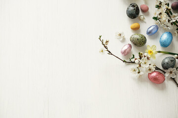 Easter flat lay. Stylish easter eggs and cherry blossom on white rustic table. Happy Easter, space...