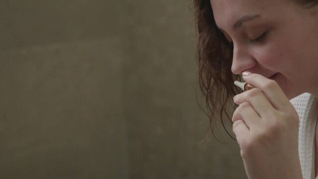close-up girl enjoys the smell of aromatic oil in the spa, chooses massage oils