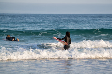 Mit dem Surfbrett in die Wellen an der Küste von St. Ives