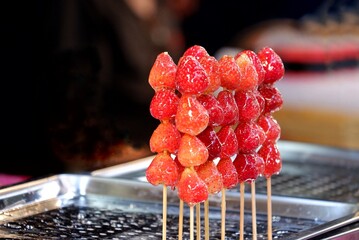 A group of candied strawberries in a stick and selling in the night market 