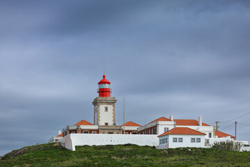 Fototapeta na wymiar Cabo da Roca lighthouse on the cliffs from Atlantic Ocean, the most western point of Europe. Travel to this landmark from Portugal. Cabo da Roca landscape.